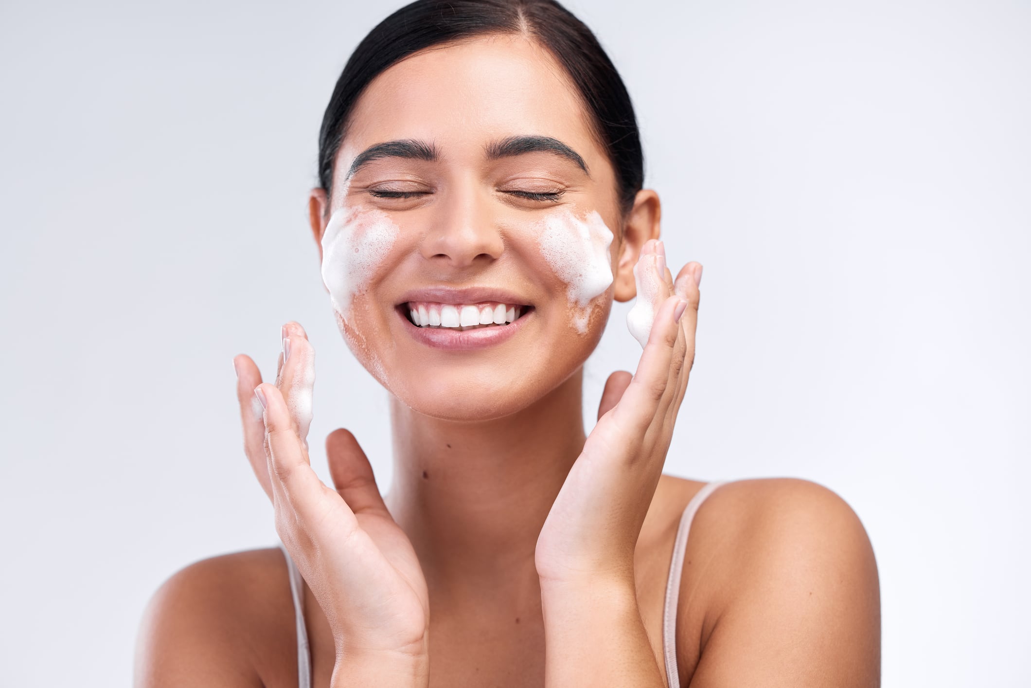 Woman washing face with foam cleanser