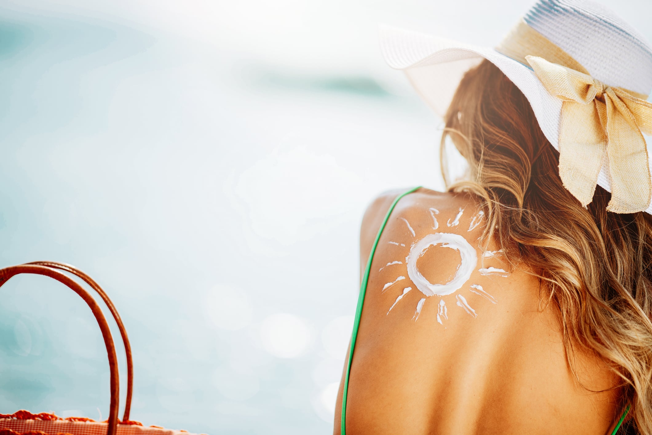 Lady. Summer. Beach. Love. Beautiful woman at beach using sun lotion. Shallow DOF. Developed from RAW; retouched with special care and attention; Small amount of grain added for best final impression. 16 bit Adobe RGB color profile.