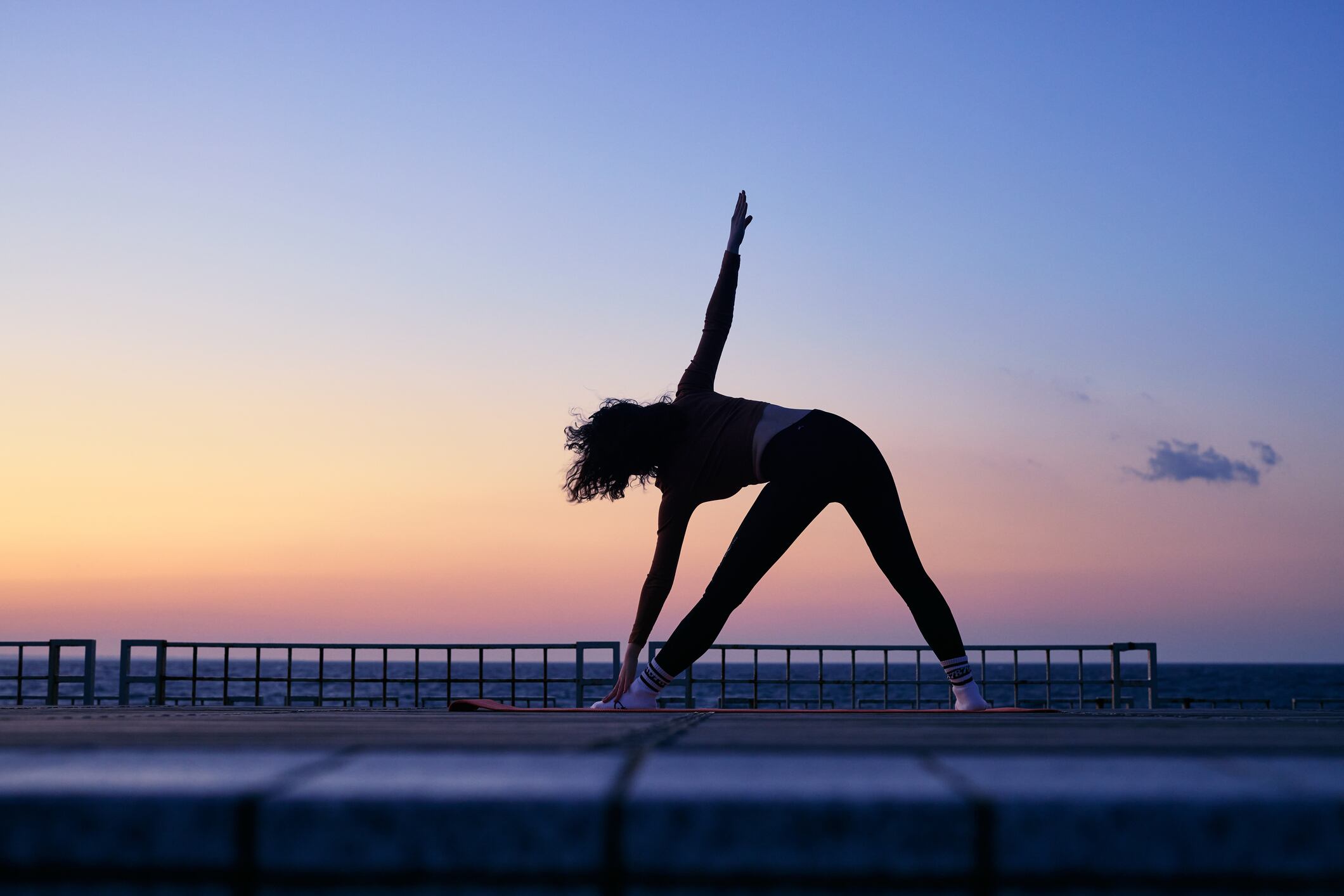 Woman doing yoga at sunset. Longevity and beauty