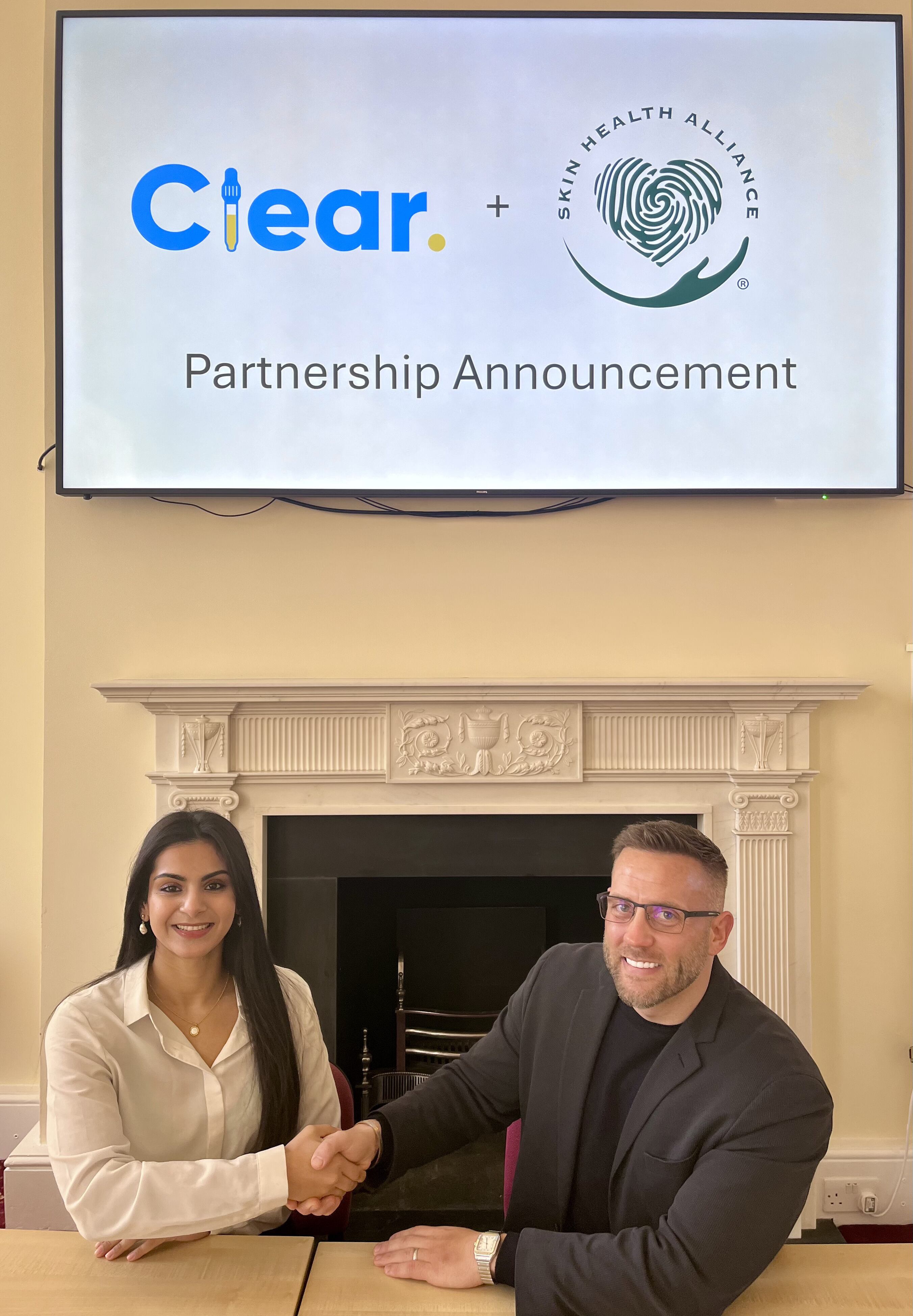 Ahana Banerjee, Founder of Clear shakes hands with James Stalley, Executive Director of the Skin Health Alliance