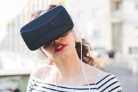 A woman in pink lipstick wearing a VR headset.
