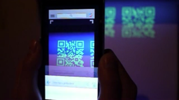 A smartphone reads a QR code printed with a fluorescent ink that is only visible under ultraviolet light. 